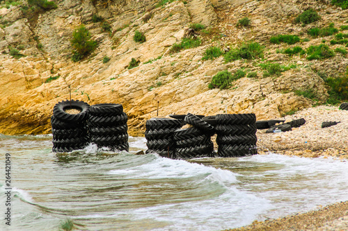 Old, used tires on the beach full of with sand. Results with plastic pollution. Saros, Tekirdag / Turkey