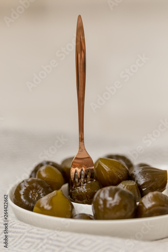 Fig jam in white ceramic plate with copper color fork