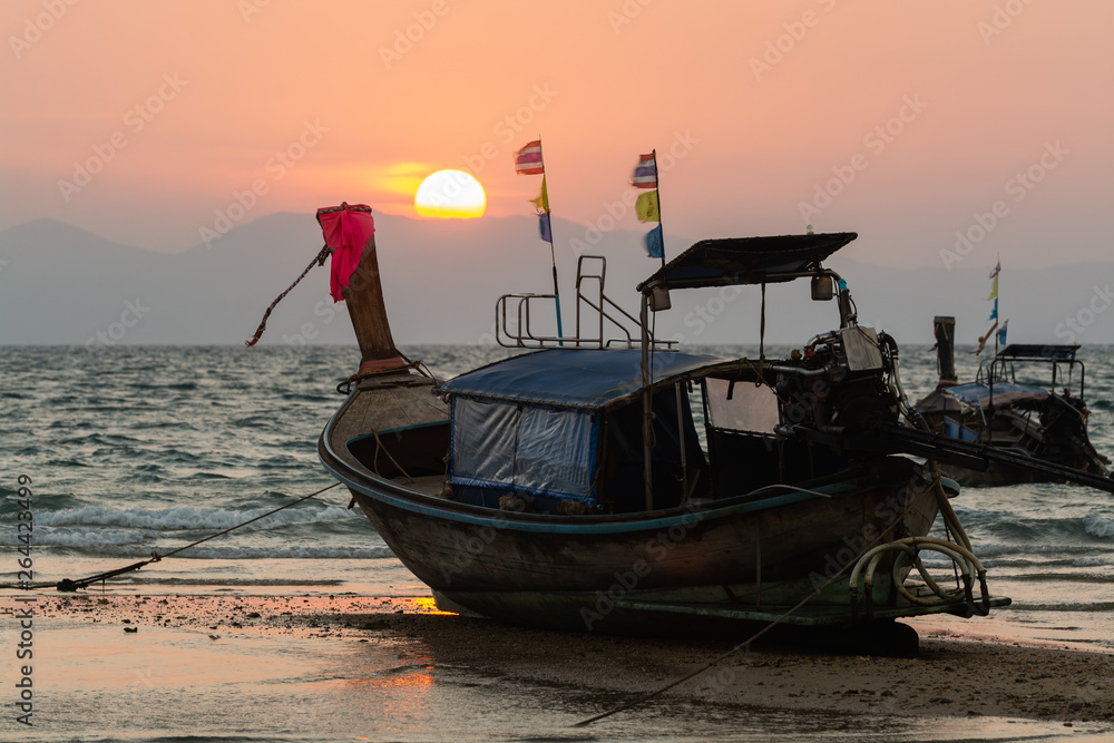 Long tail wooden boats moored at Klong Muang beach at sunset in Krabi province, Thailand Long tail wooden boats moored at Klong Muang beach at sunset in Krabi province, Thailand
