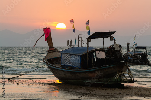 Long tail wooden boats moored at Klong Muang beach at sunset in Krabi province, Thailand
