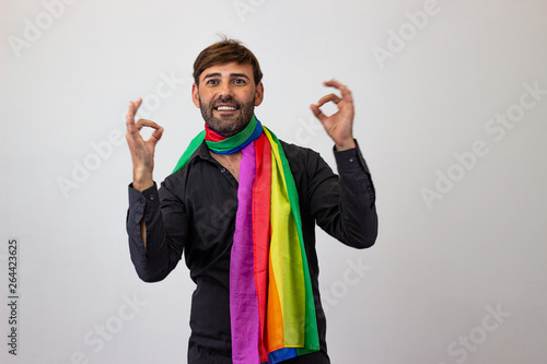 Portrait of handsome young man with gay pride movement LGBT Rainbow flag and brown hair and a suffering expression, looking at the camera. Isolated on white background. photo