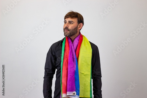 Portrait of handsome young man with gay pride movement LGBT Rainbow flag and brown hair looking ashamed, facing forwards and looking at the horizon. Isolated on white background. photo