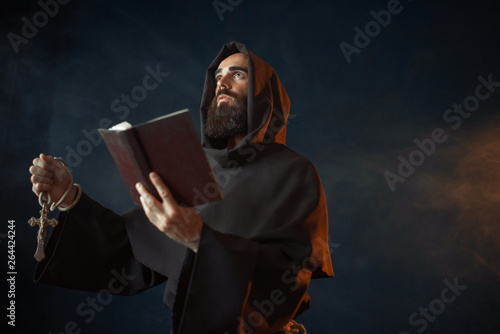 Fototapeta Medieval monk with spellbook calling the spirits