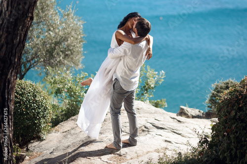 Photos Man holding woman in his arms wrapped around her waist and she is holding on to him