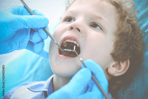 Fototapeta Naklejka Na Ścianę i Meble -  Doctor and patient child. Boy having his teeth examined with dentist. Medicine, health care and stomatology concept