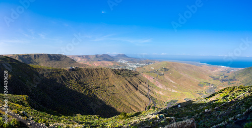 Spain, Lanzarote, XXL scenic panorama of green mountainous landscape surrounding palm tree town haria