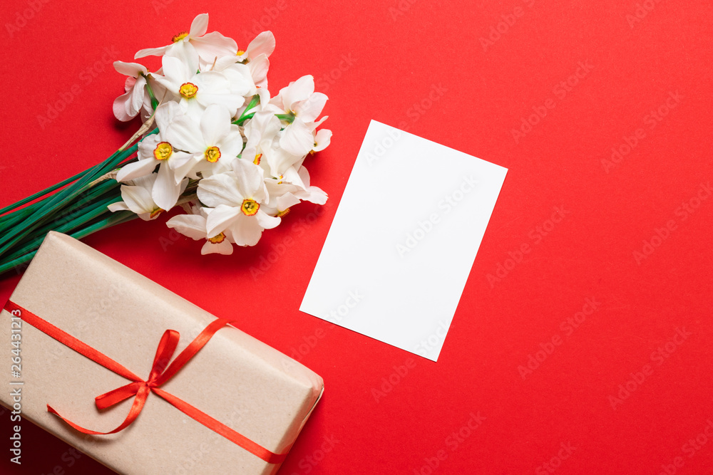 Kraft envelope with a blank sheet of paper and a red tulip on a red background, top view with space for text Kraft envelope with a blank sheet of paper and a red tulip on a red background, top view with space for text