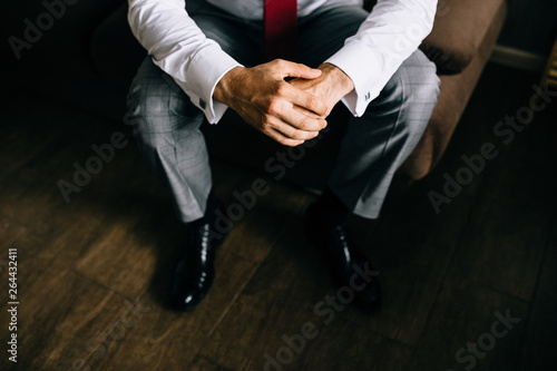 Hands of groom getting ready in suit