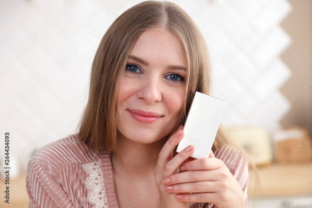 Closeup portrait of beautiful young girl holding skincare cosmetics, box with face cream, serum. Place for text, copy space. Concept photo shoot luxury natural cosmetics shop Closeup portrait of beautiful young girl holding skincare cosmetics, box with face cream, serum. Place for text, copy space. Concept photo shoot luxury natural cosmetics shop