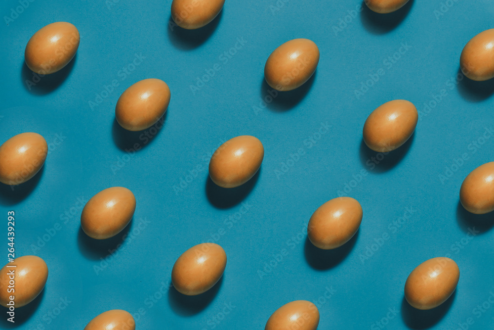 Pattern of Yellow Easter eggs on a blue background. Creative concept