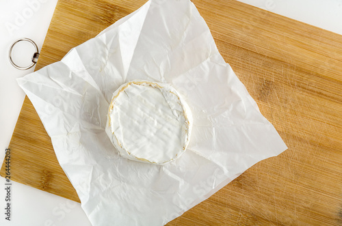 Camembert cheese on the chopping wooden board