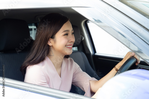 Asian women driving a car and smile happily with glad positive expression during the drive to travel journey, People enjoy laughing transport and relaxed happy woman on roadtrip vacation concept © comzeal