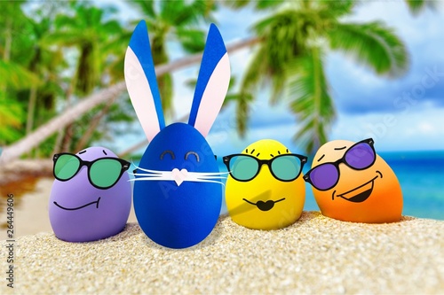 Funny eggs with sunglasses on exotic beach background