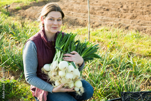 Female holding armful of onion photo