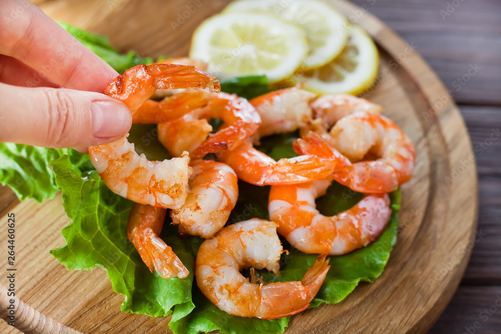 female fingers take fried shrimp in the background of the plate with them female fingers take fried shrimp in the background of the plate with them
