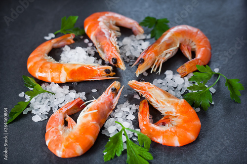 boiled shrimps with salt and lemon are beautiful against a dark background © Oksana