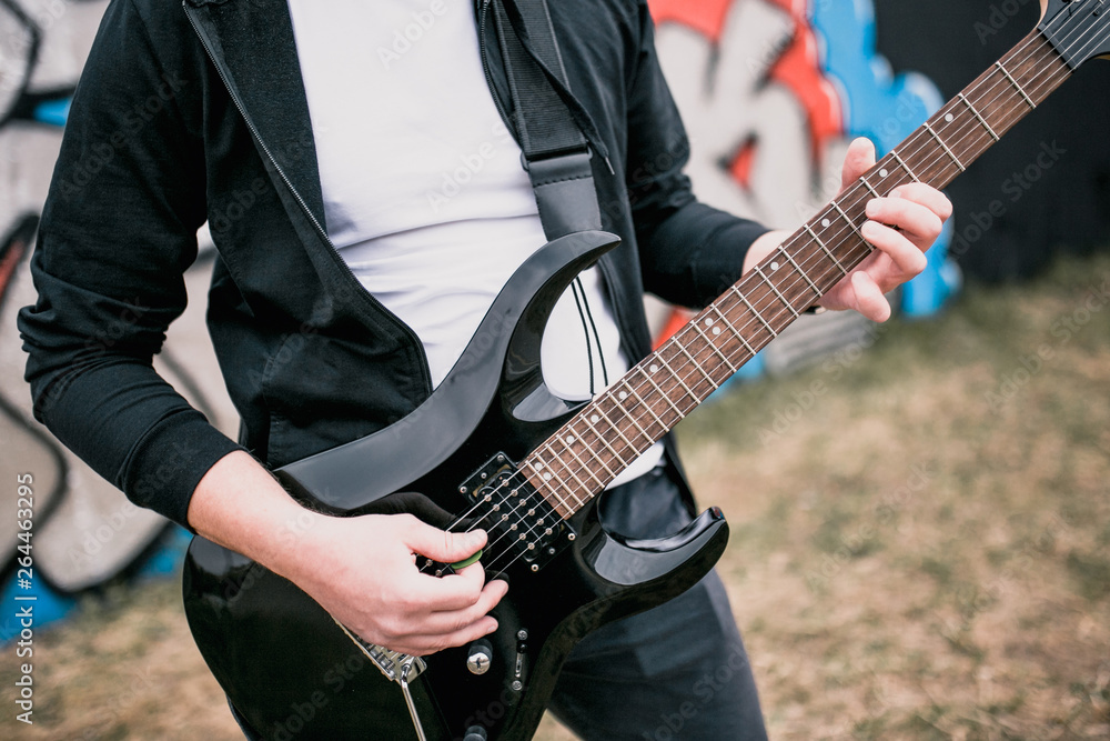Man with a black electric guitar outdoors - blues rock music Man with a black electric guitar outdoors - blues rock music