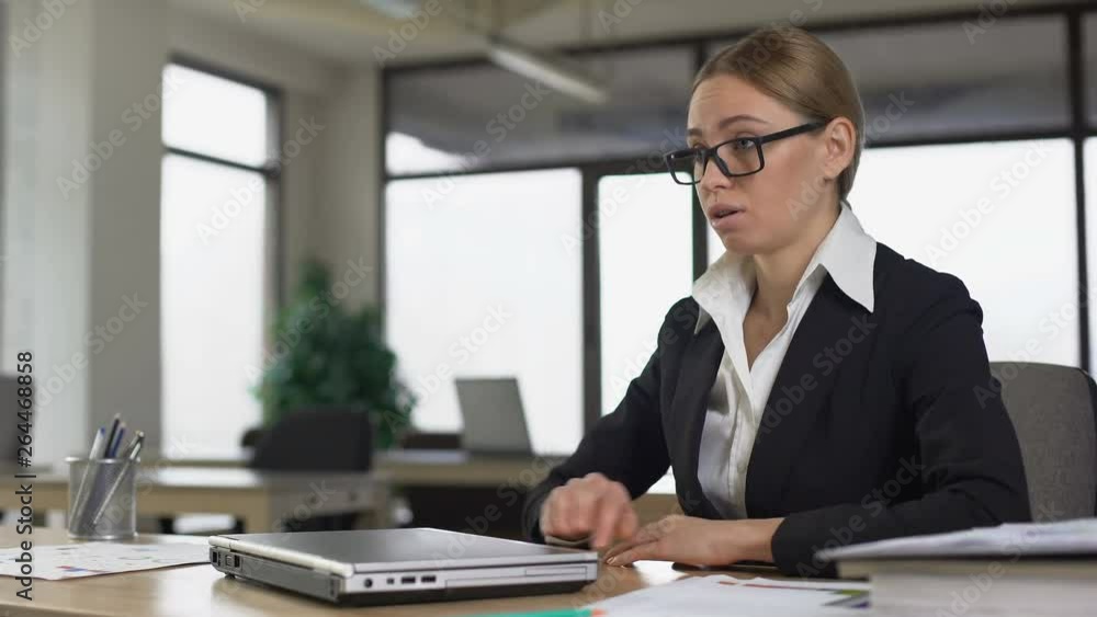 Female employee reading bad news on email, angrily closing laptop, dismissal Female employee reading bad news on email, angrily closing laptop, dismissal