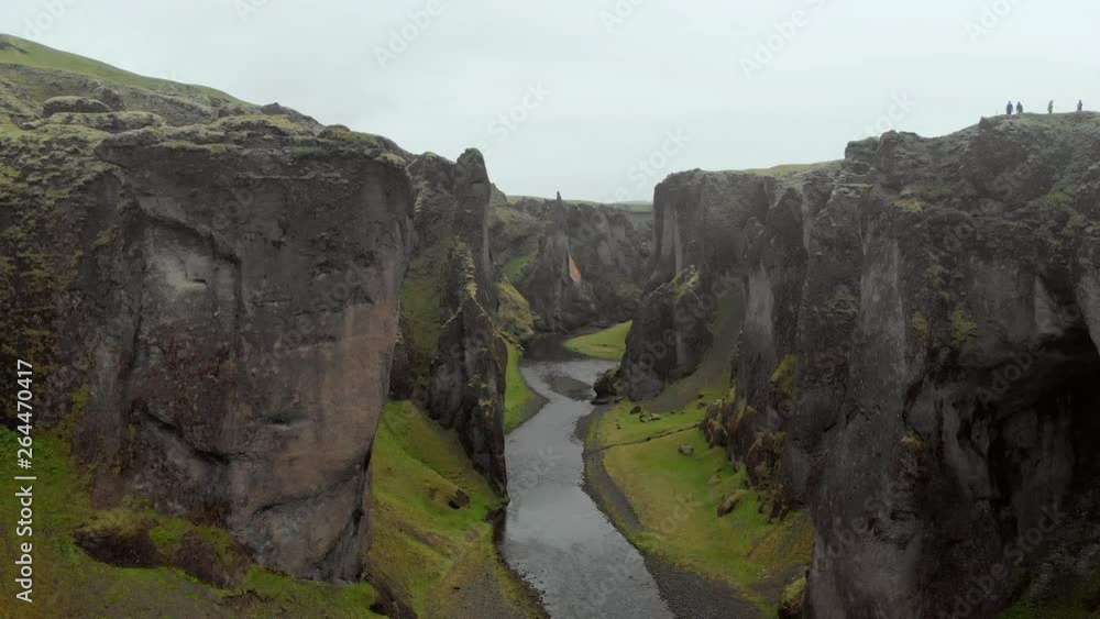 Aerial Ascend: Small River At Bottom Of Tall, Rocky Valley in Fjaorargljufur, Iceland