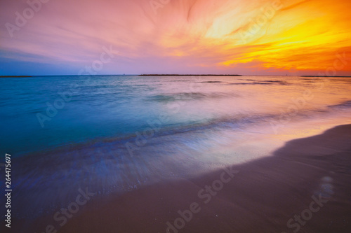 Seashore in the evening. Sunset over the sea. Beautiful beach with dramatic sunset sky