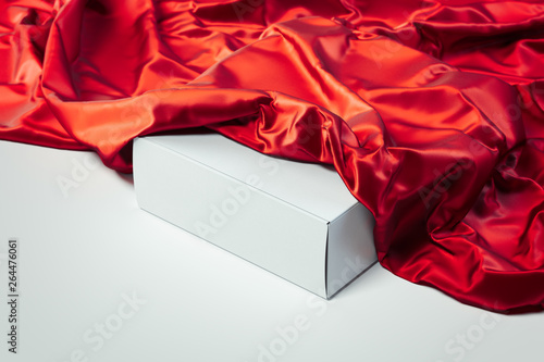 фотографія Close up of white blank box under red cloth on white background