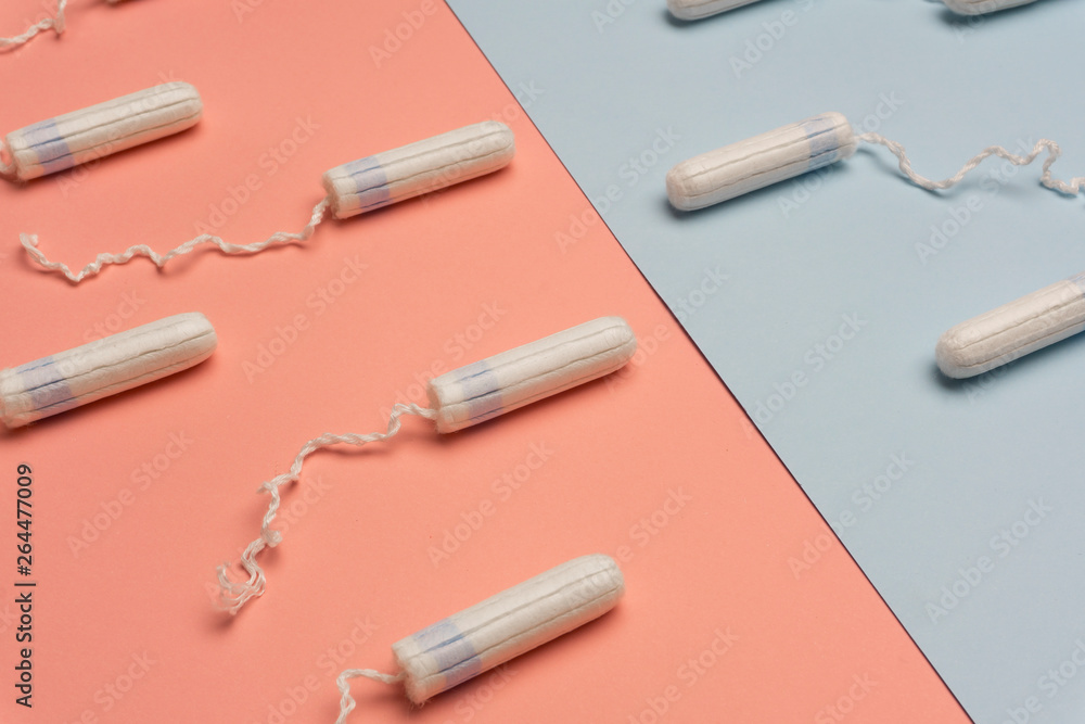 Menstruation concept with tampons and pads on bright blue background. Woman menstruation cycle concept. Menstruation concept with tampons and pads on bright blue background. Woman menstruation cycle concept.