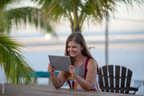 young woman with tablet on the beach
