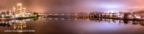 Panorama, foggy view from the central bridge over the river to the both sides of Umea city with pedestrian bridge in the middle, Vasterbotten municipality, Sweden © Alexandre Patchine