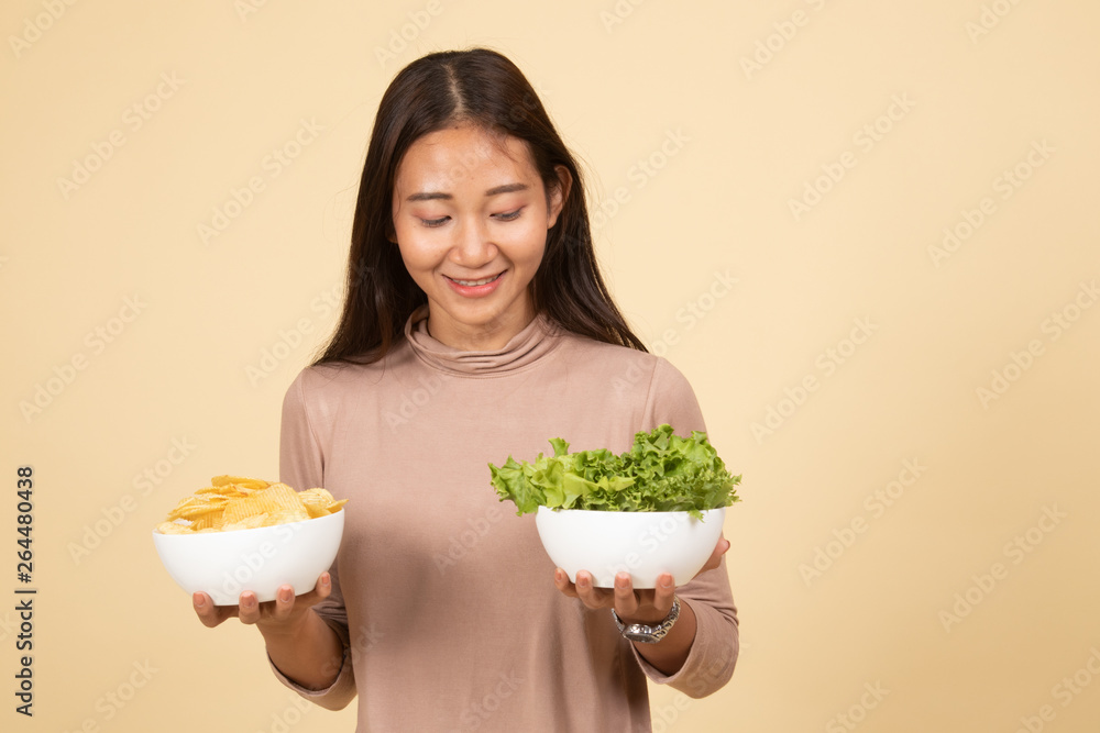 Young Asian woman with potato chips and salad. Young Asian woman with potato chips and salad.