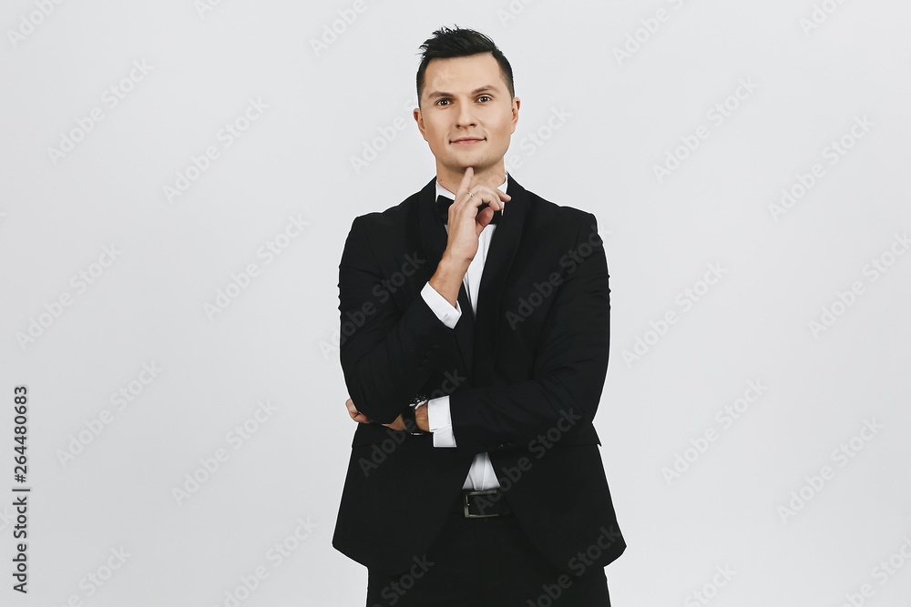 Young businessman in black classic tuxedo and bow tie, isolated at white background Young businessman in black classic tuxedo and bow tie, isolated at white background