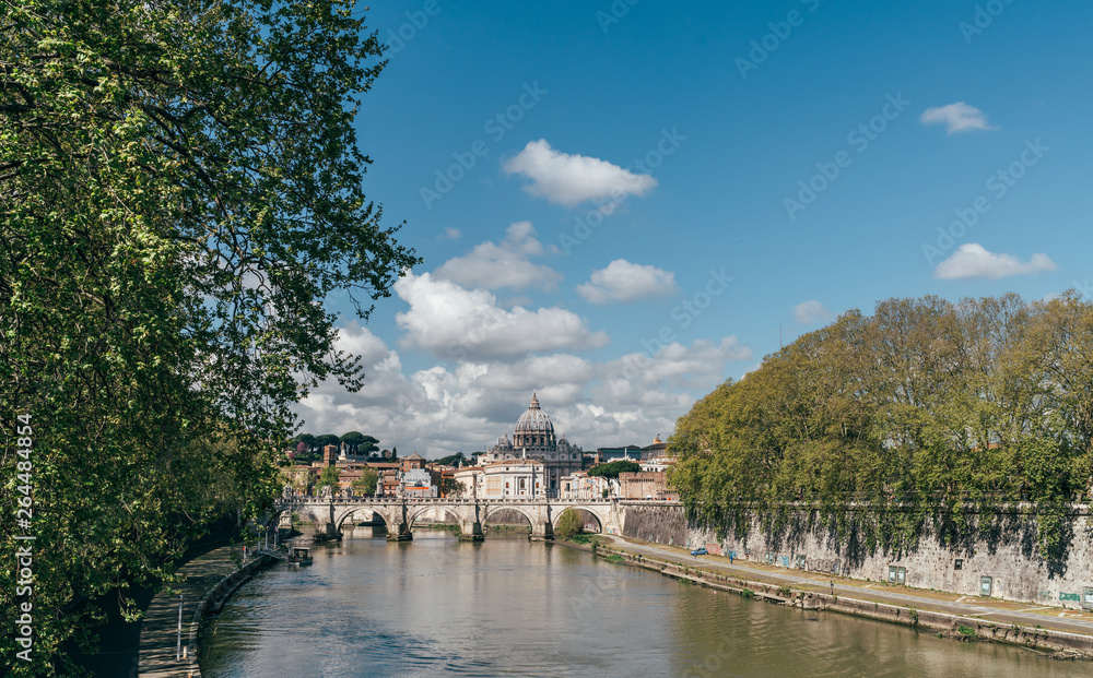 Tiber river cityscape in the Rome city centre with St. Peter's Basilica (Vatican) on the background.