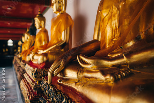 Collection of Buddha figures gilded with gold leaves by King Rama I at Phra Rabiang  cloister in Wat Pho (Wat Po) temple in  Bangkok, Thailand. photo