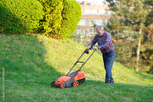 man mows the lawn grass with a lawn mower