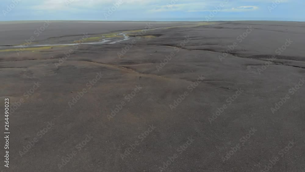 Aerial Exit: Dark, Sandy Plain Stretching To Horizon Under Blue Sky in Solheimasandur, Iceland Aerial Exit: Dark, Sandy Plain Stretching To Horizon Under Blue Sky in Solheimasandur, Iceland