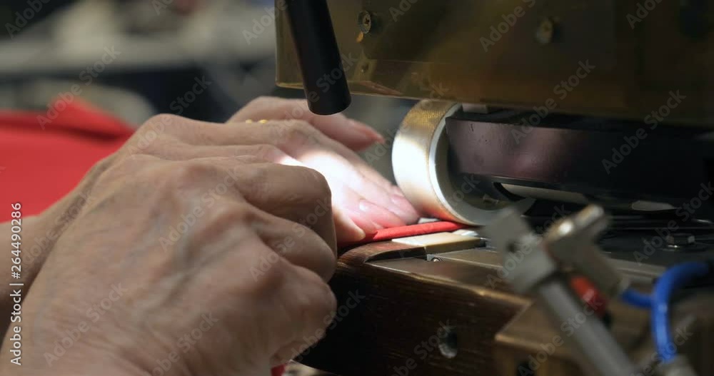 In a slow motion video in a garment factory, women press (cut) various pieces of clothing and fabric locks and various materials using different machines. Concept of: Work, Factory, Seamstress. In a slow motion video in a garment factory, women press (cut) various pieces of clothing and fabric locks and various materials using different machines. Concept of: Work, Factory, Seamstress.