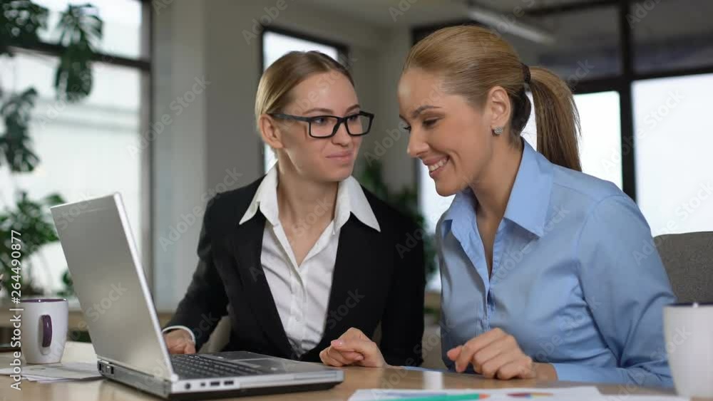 Two female workers reading email about promotion, happy for each other, support Two female workers reading email about promotion, happy for each other, support