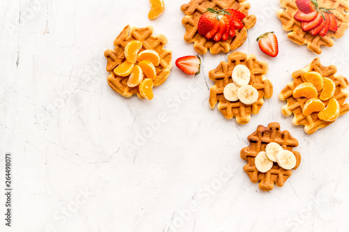 Traditional belgian waffles with fruit topings on white marble background top view mock up