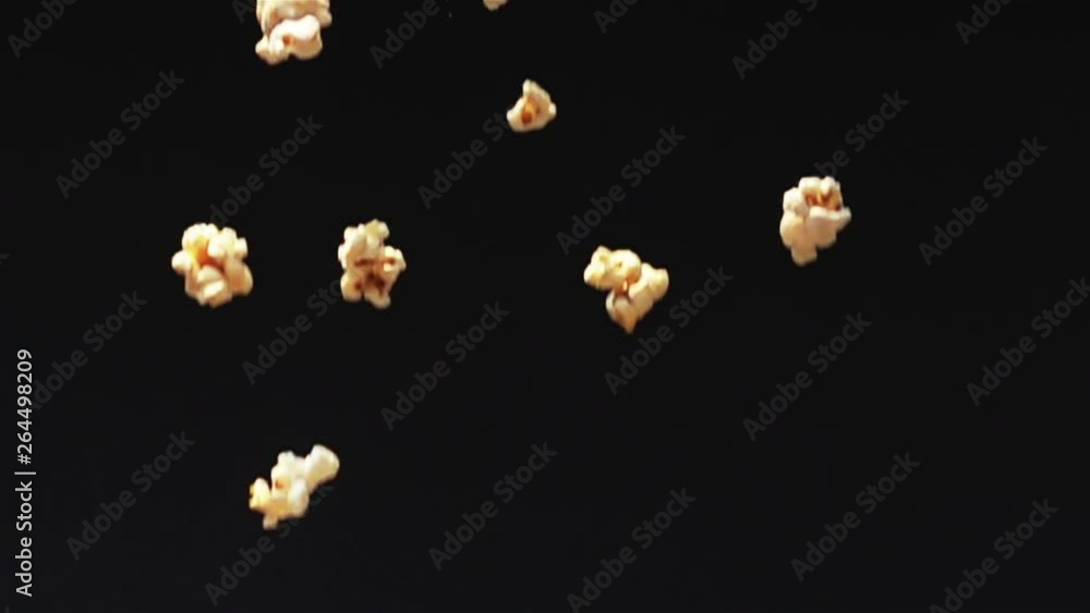 Fresh popcorn fall down to the ground on black background in Slow Motion Fresh popcorn fall down to the ground on black background in Slow Motion