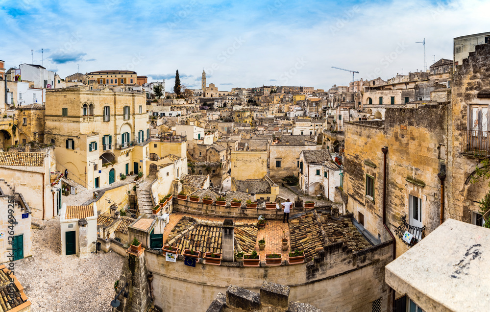 Long panoramic views of the rocky old town of Matera with its stone roofs.
