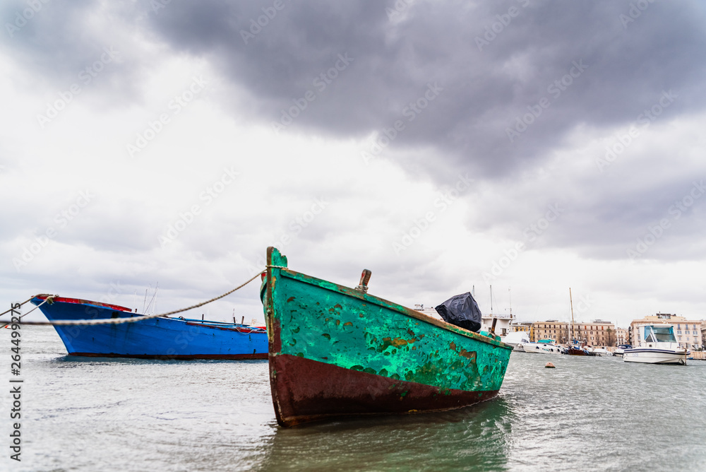 Small boat moored to Bari port, Italy, during a storm at sea.