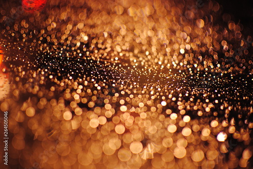 imagem de um vidro com gotas de chuva com bokeh