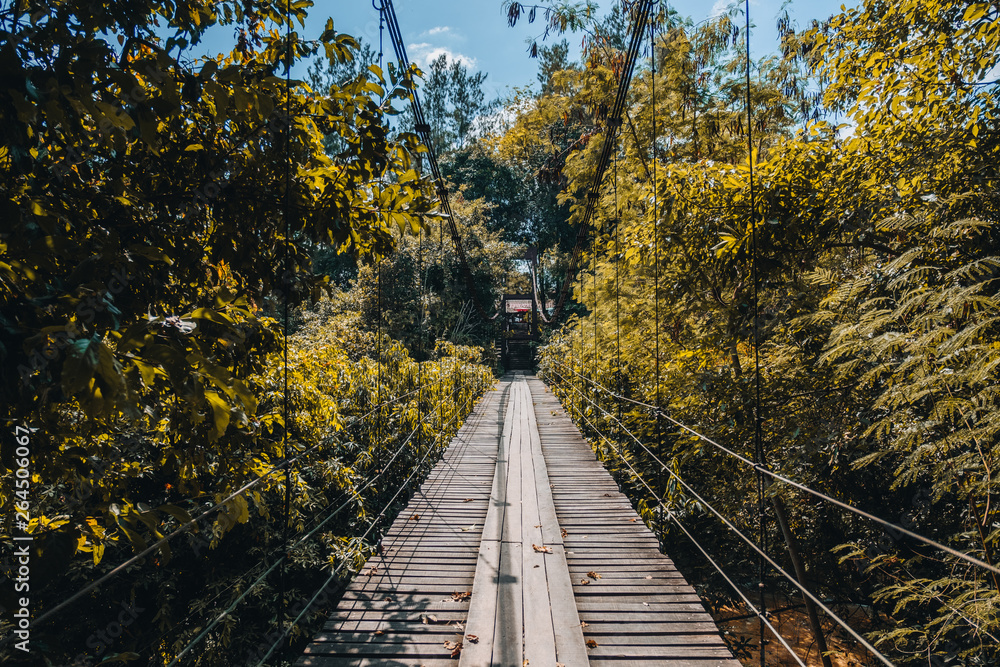 Old wooden bridge with metal railings in Thailand