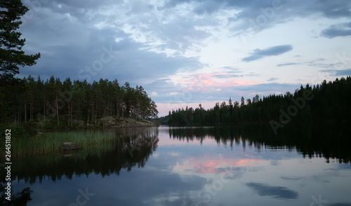 Sunset over a calm lake in sweden, the clouds are reflecting on the calm surface