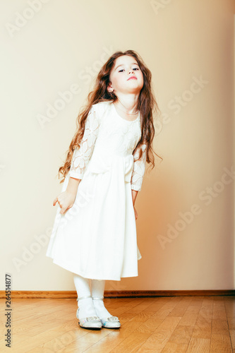 little cute girl with long curly hair posing cheerful on white background, lifestyle people concept