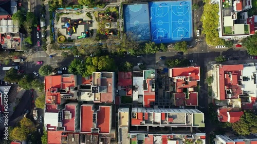 DRONE FLIGHT OVER PARK IN MEXICO CITY RESIDENTIAL AREA. KIDS PLAYGROUND COLORFUL, BLUE BASKETBALL COURT, AND CITY STABLISH photo