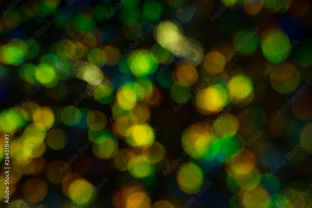 Blurred golden and green bokeh circles on dark background. Defocused lens flare glow. Blurred golden and green bokeh circles on dark background. Defocused lens flare glow.