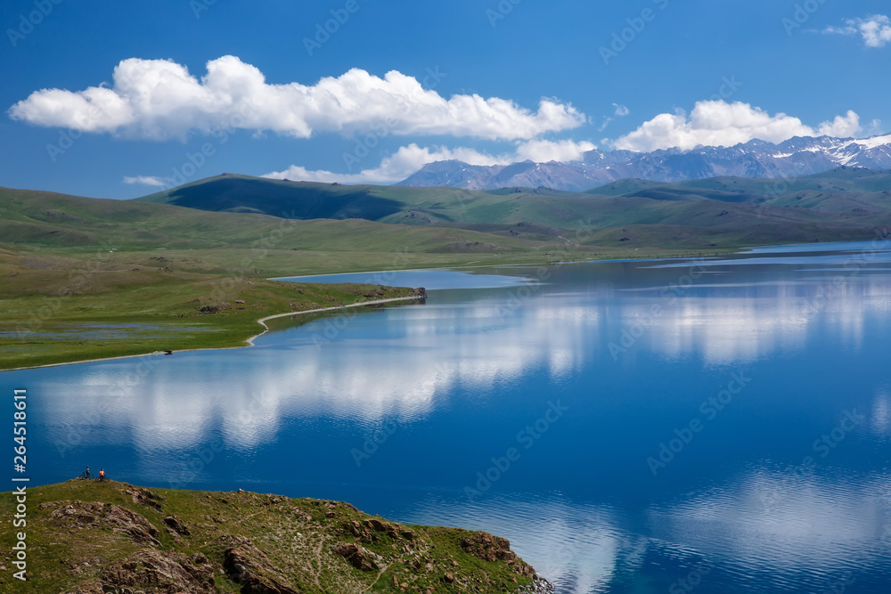 Fototapeta premium The sky with beautiful clouds reflected on the surface of a mountain lake