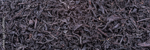 Background of dried tea leaves of dark color. Macro.