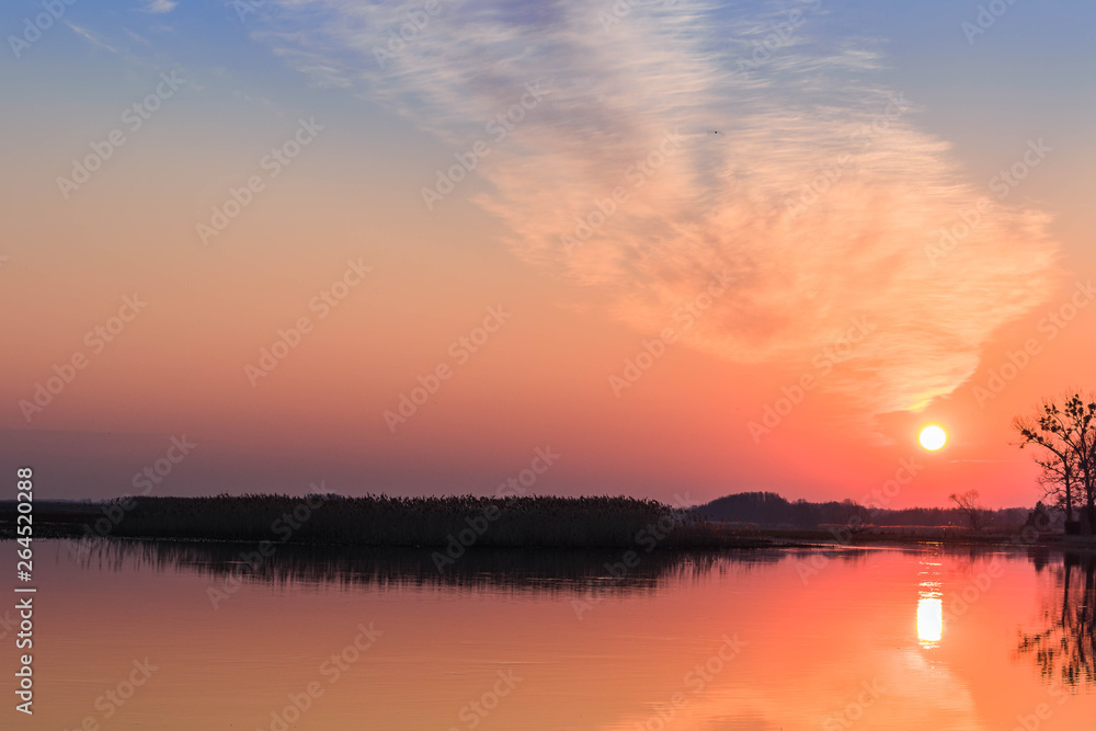 Peaceful landscape with the colorful sky during sunrise over the river