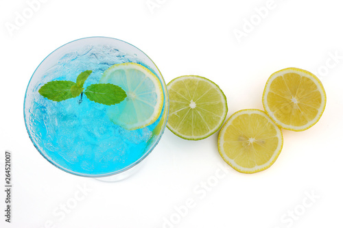 Blue cocktail with lime slice and mint in glass top view isolated on white background